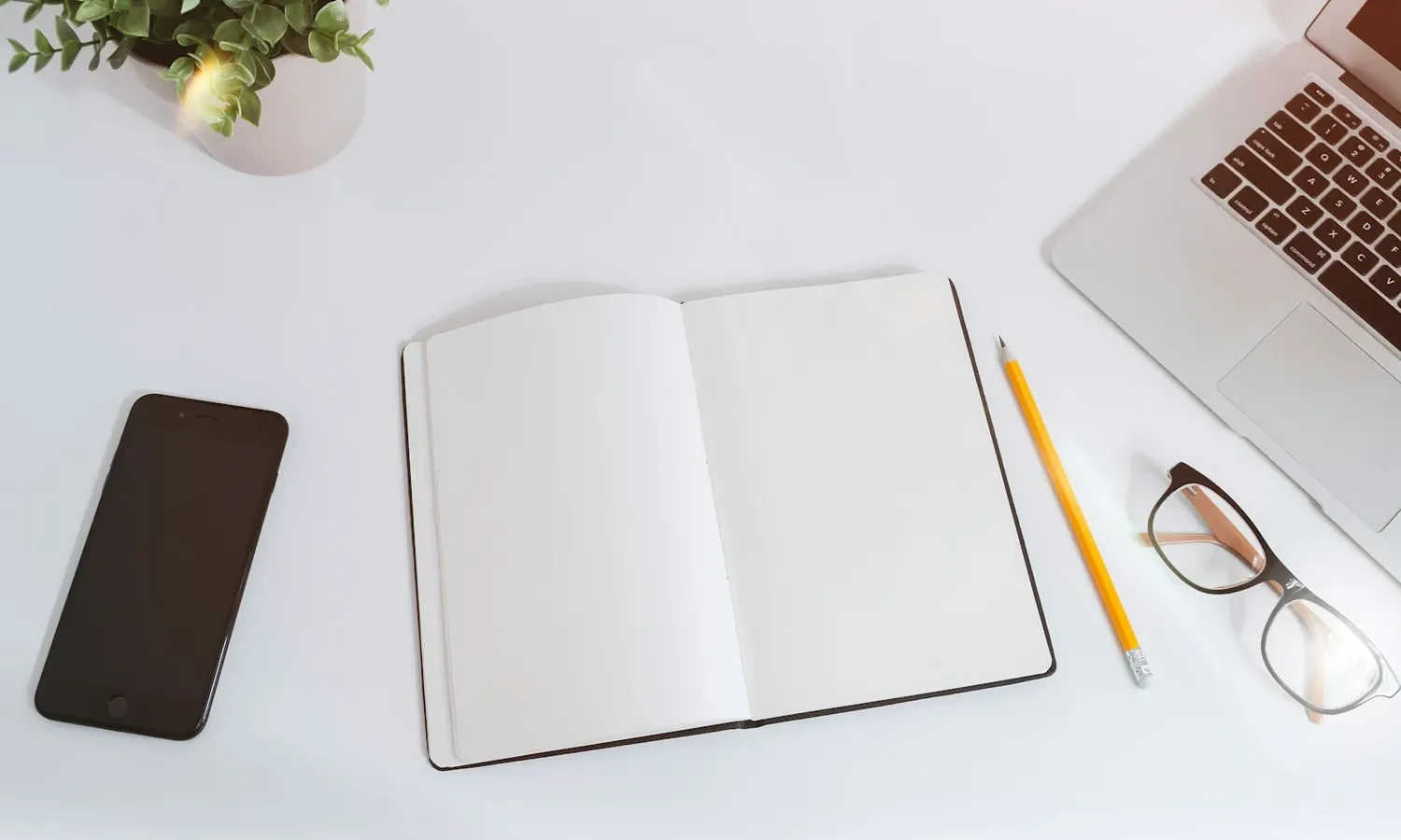 Carnet ouvert, crayon et téléphone sur un bureau
