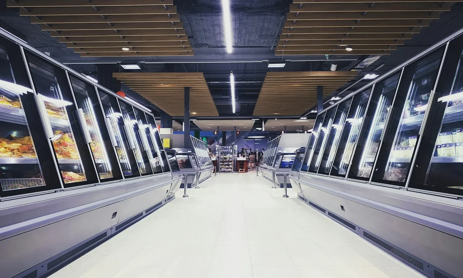 Allée de congélateurs vitrés dans un magasin