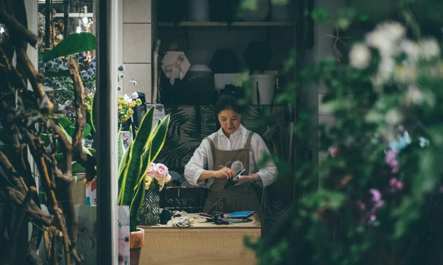 Commerçante au comptoir de sa boutique de fleurs