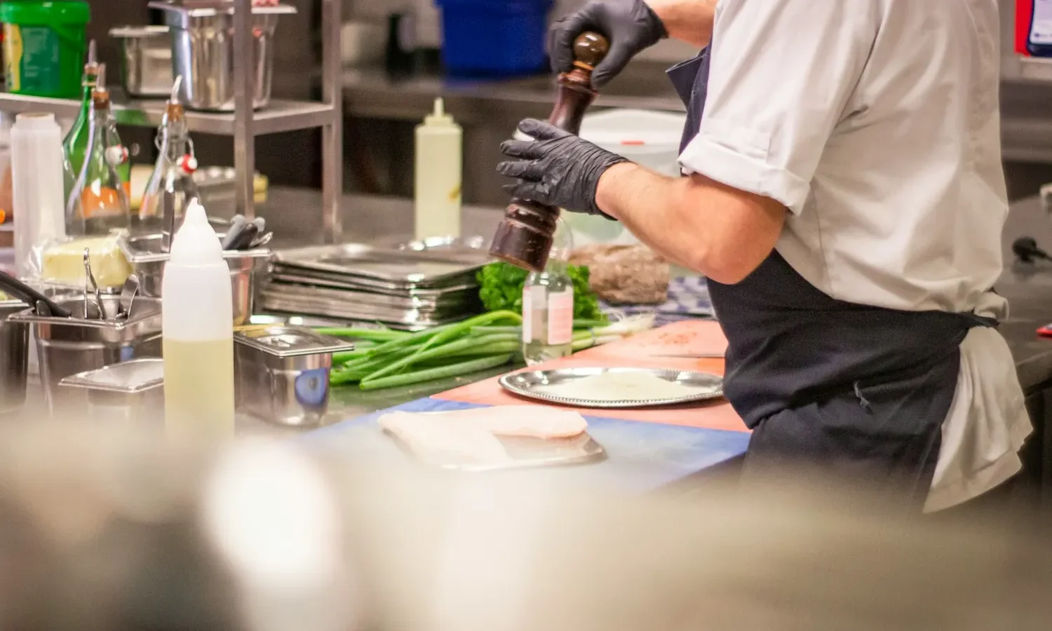 Cuisinier assaisonnant un plat en cuisine professionnelle