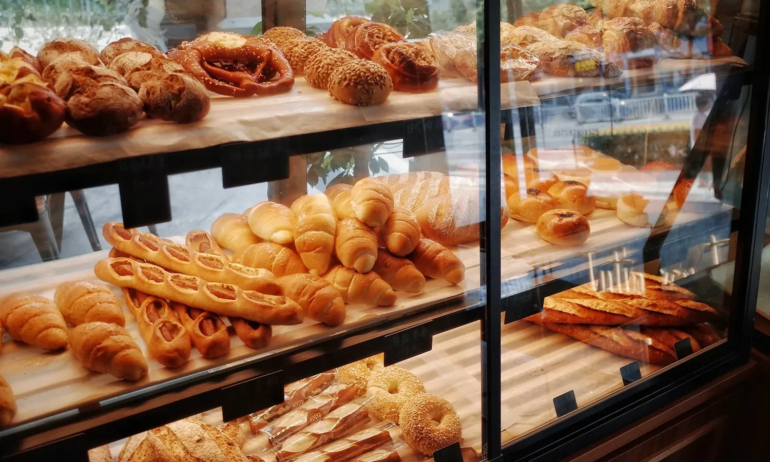Vitrine de boulangerie garnie de pains, viennoiseries et baguettes